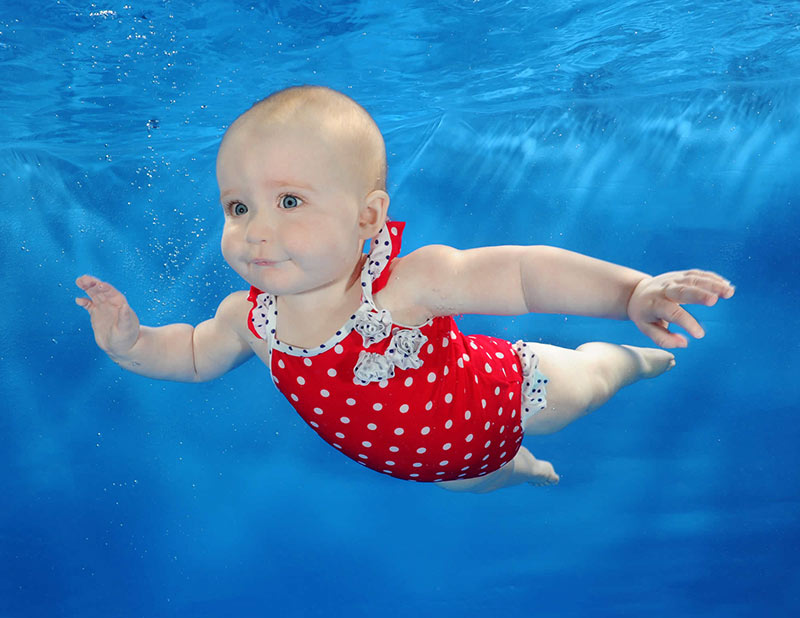baby swimming lessons - baby in red polka dot costume swimming - Swim